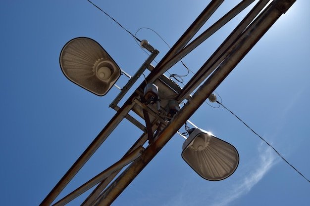 Directly below shot of street lights against blue sky