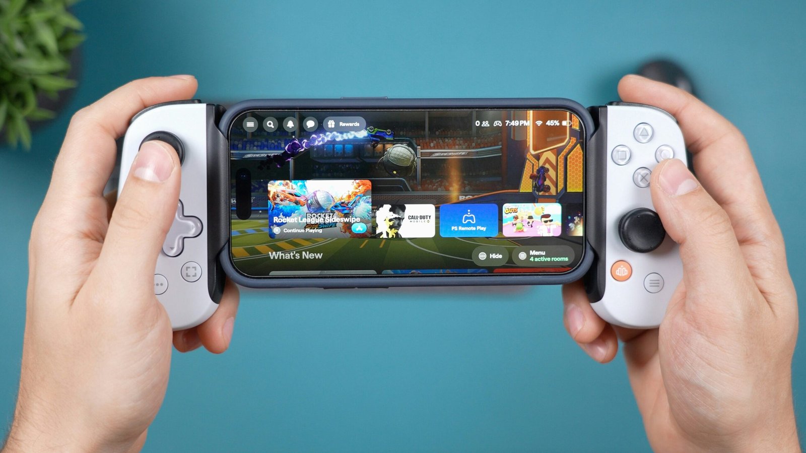 Hands holding smartphone with game controller attachment