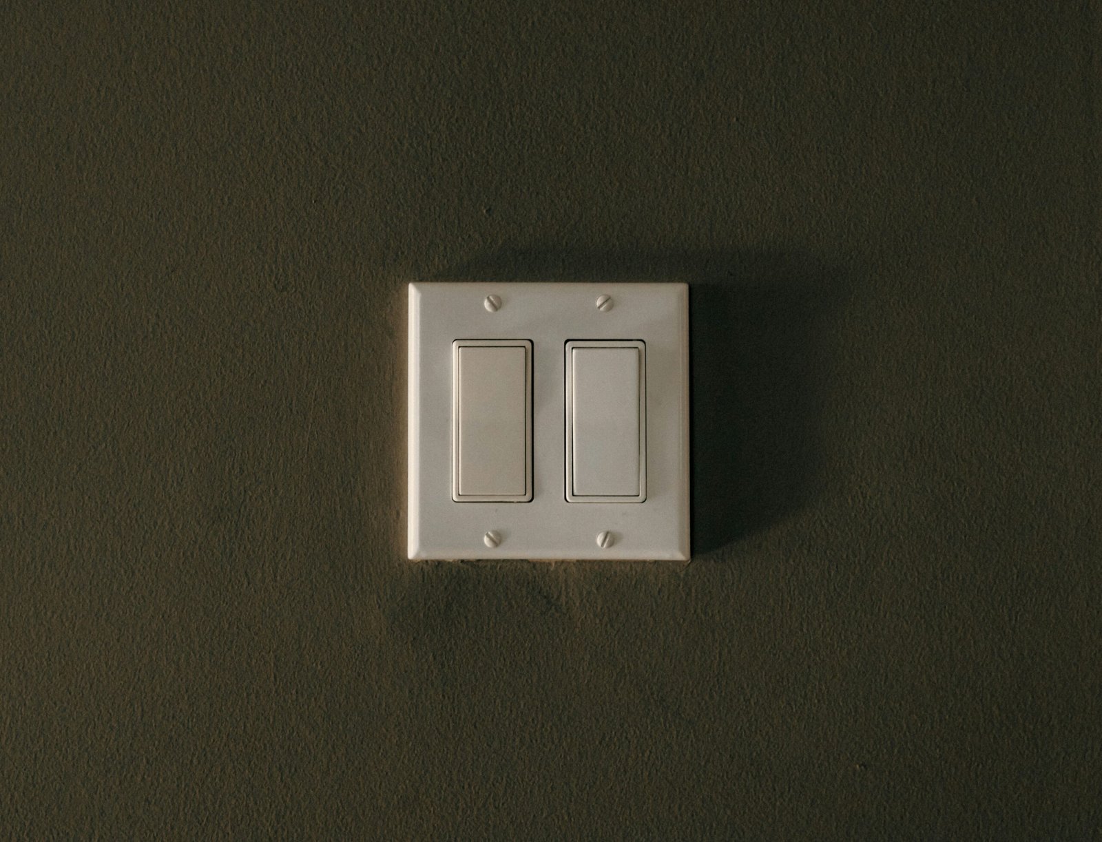 a white light switch sitting on top of a wall