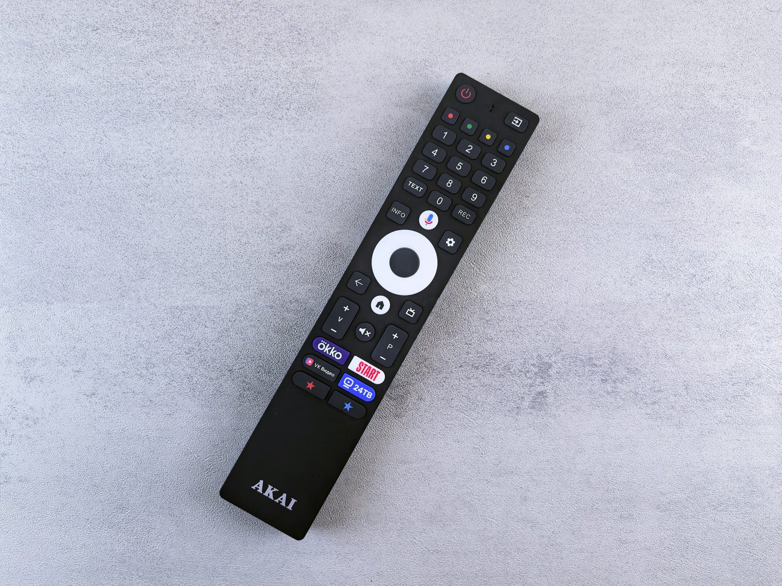 Black akai remote control on a grey surface