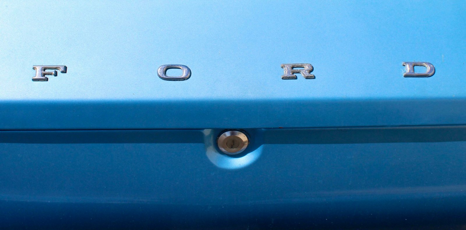 Close up of the ford logo on a blue car.