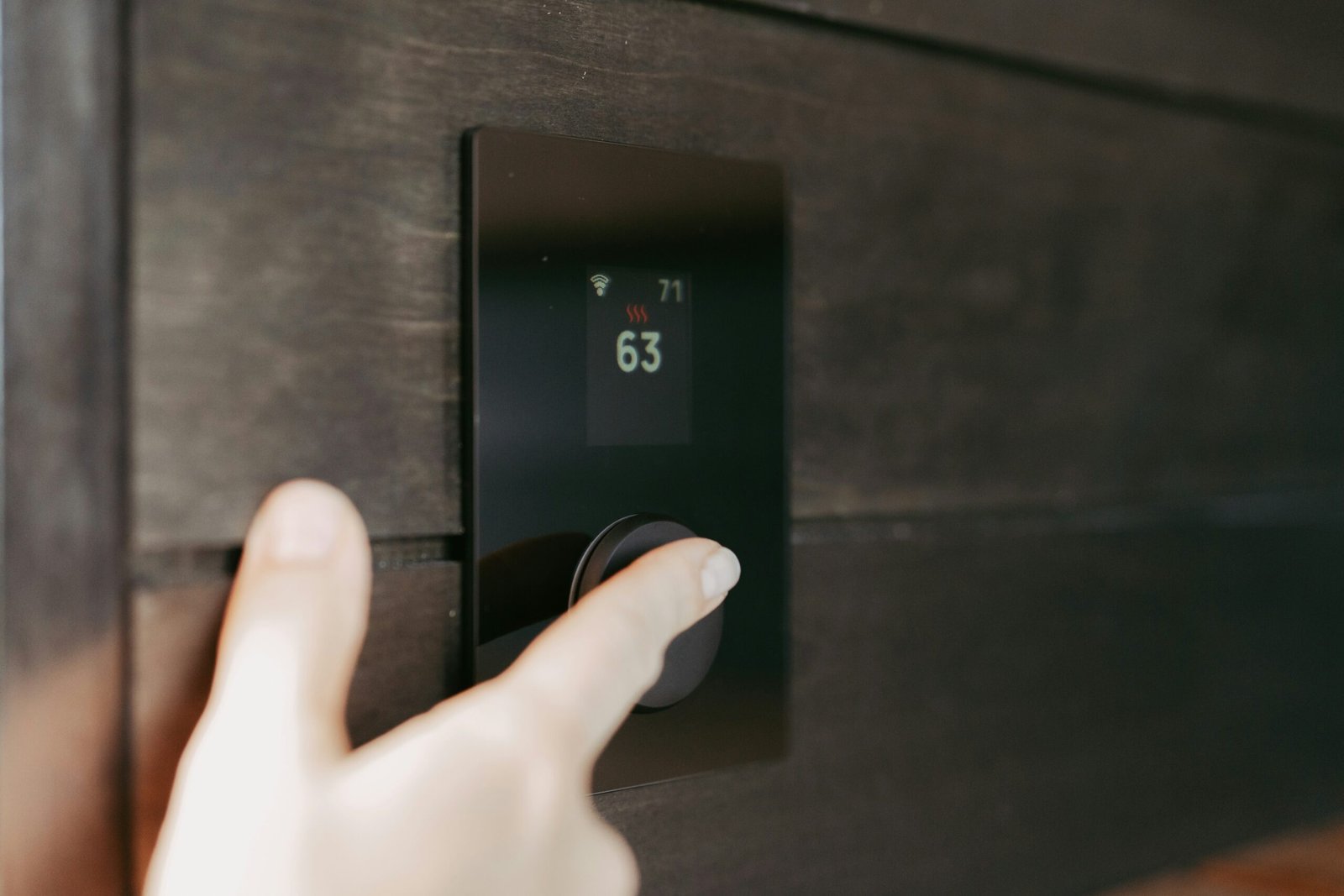 Hand adjusting a digital thermostat display