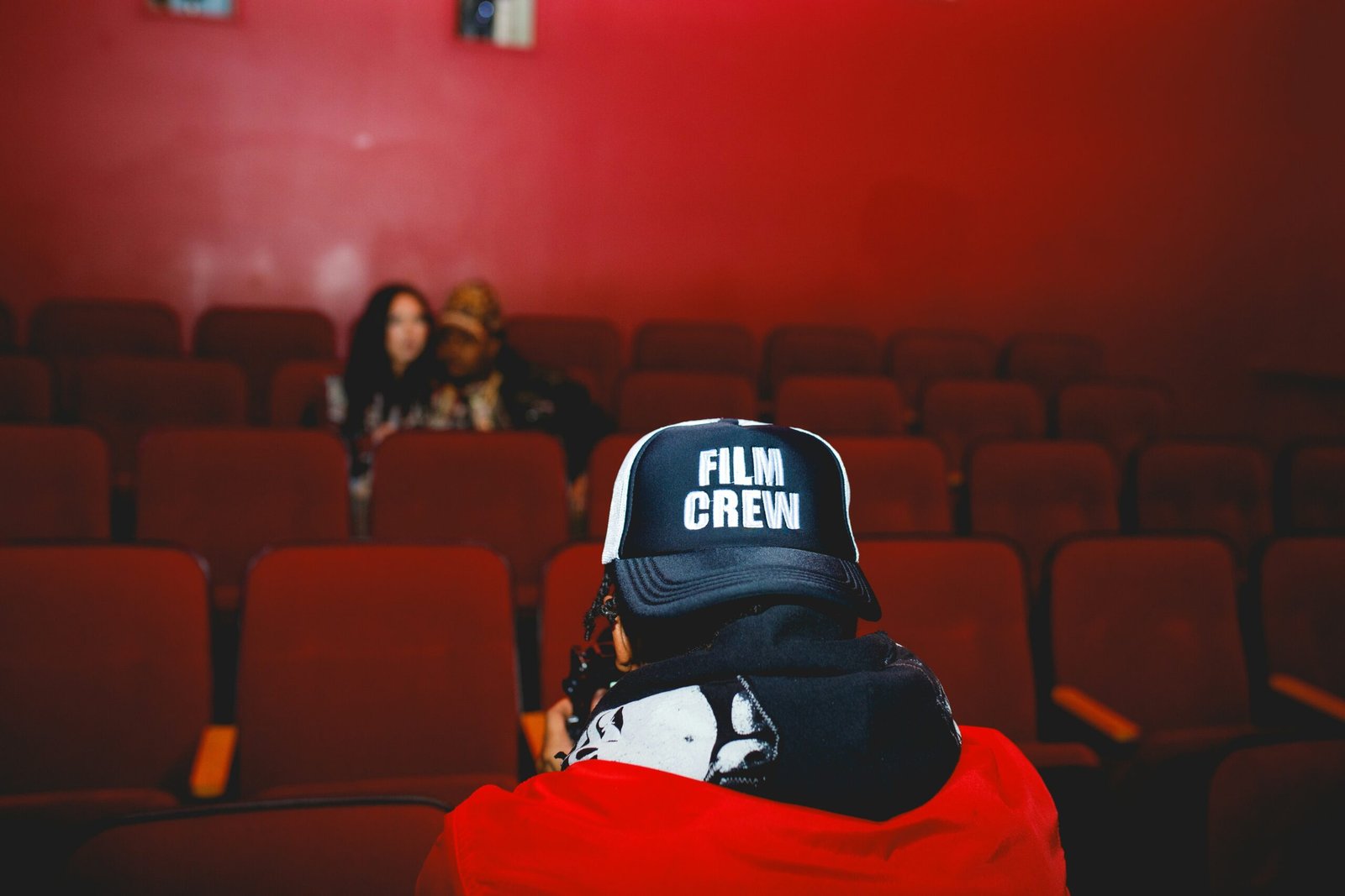 A person sitting in a red chair in front of a red wall