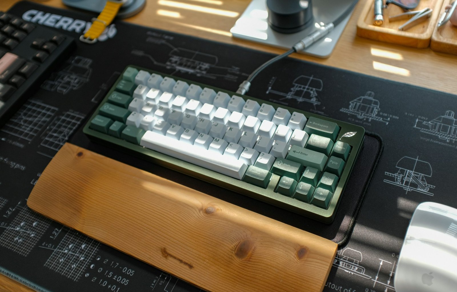 A mechanical keyboard sits on a desk mat.