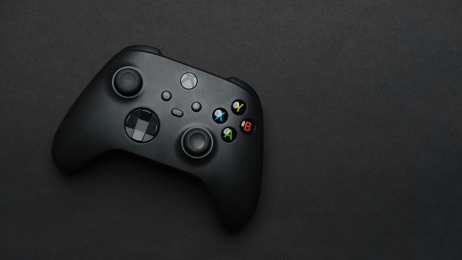 A close up of a controller on a black surface