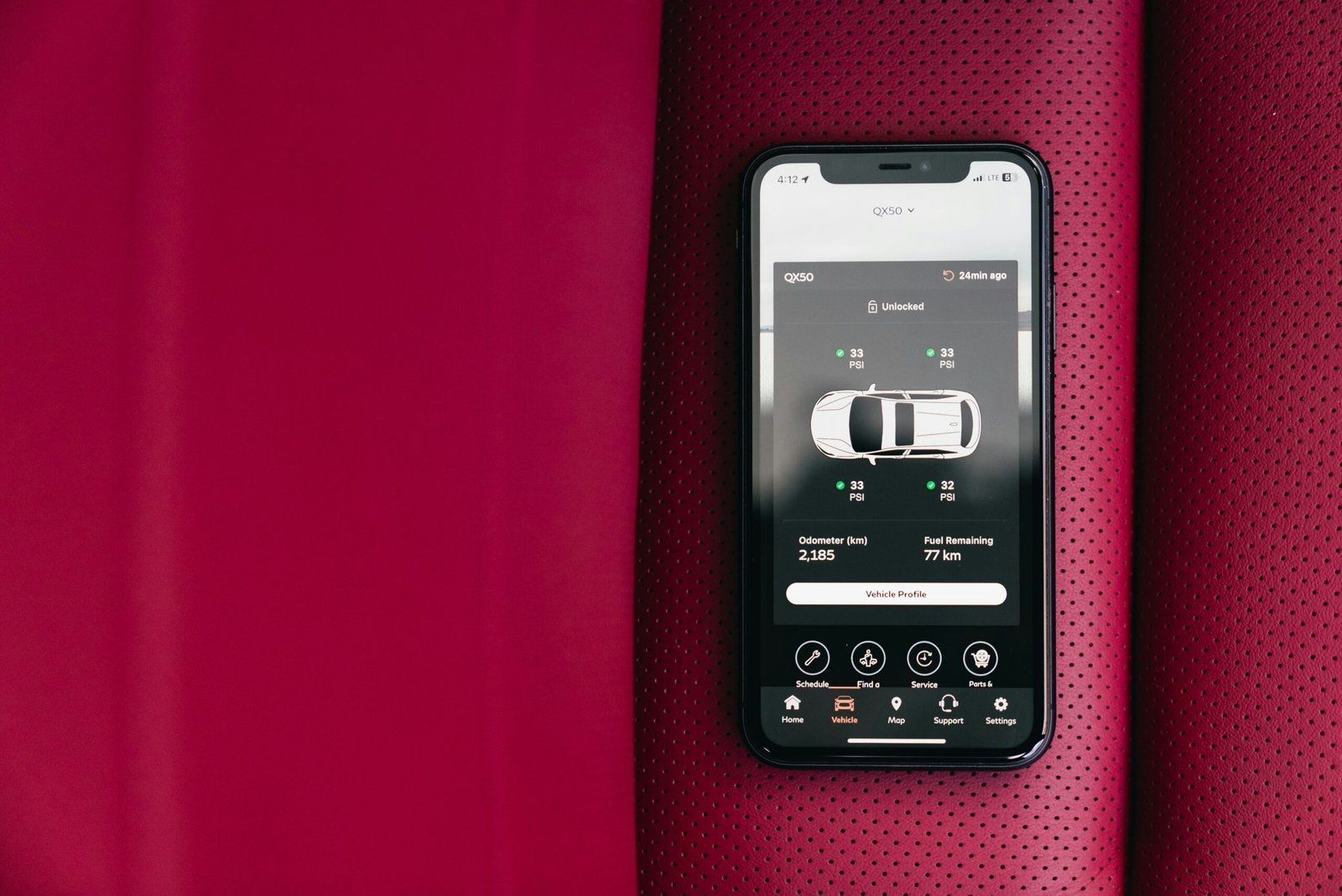 Smartphone displaying car control app on red seat