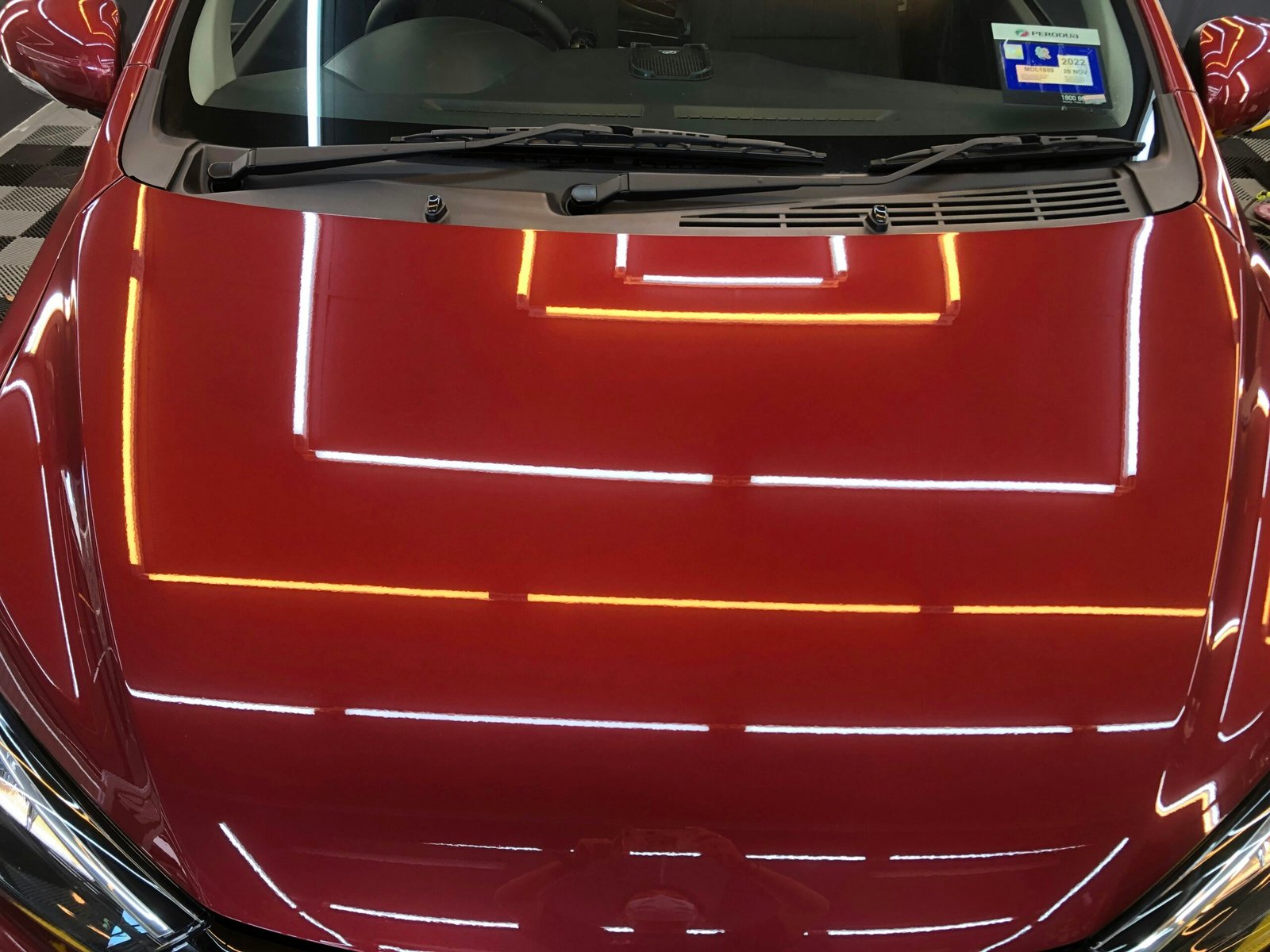 the hood of a red car with yellow lines on it