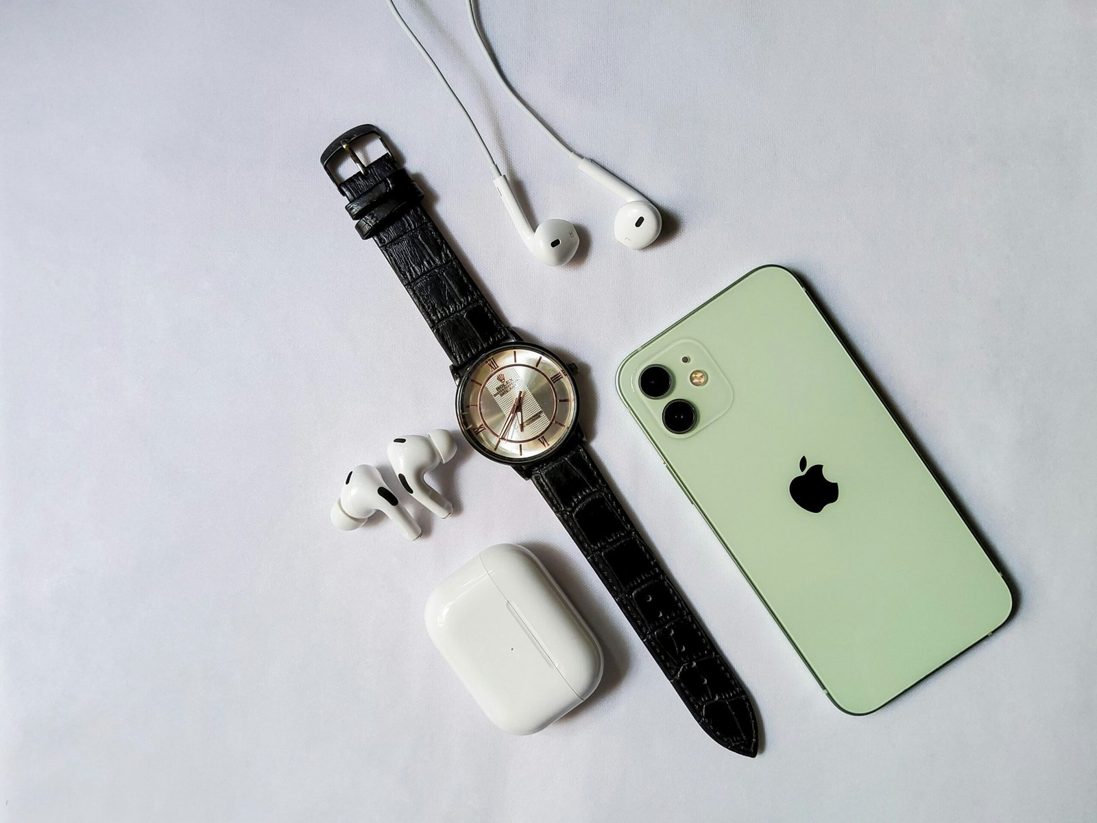 a watch, headphones, and an iphone on a table