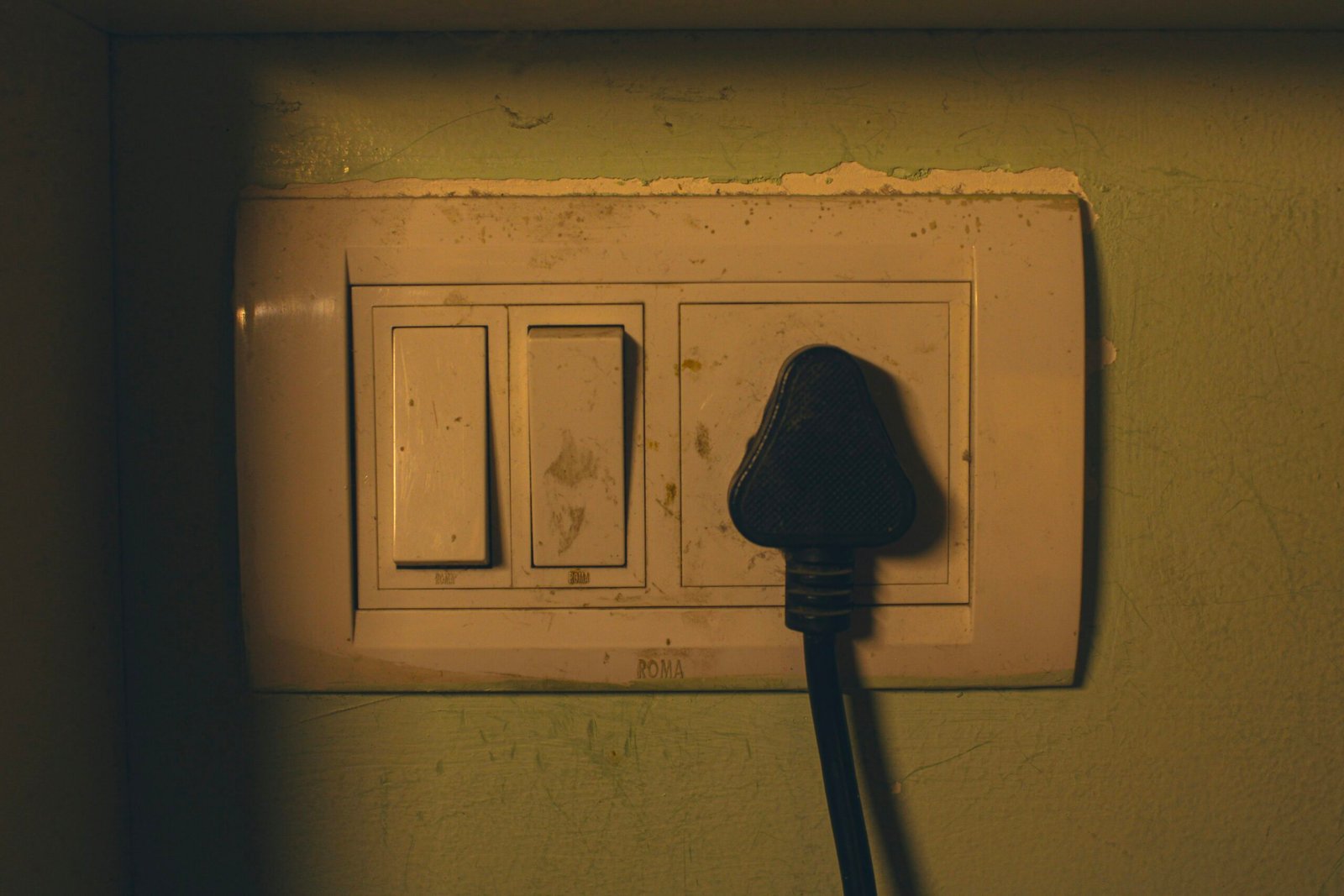 Electrical outlet with a black plug inserted.