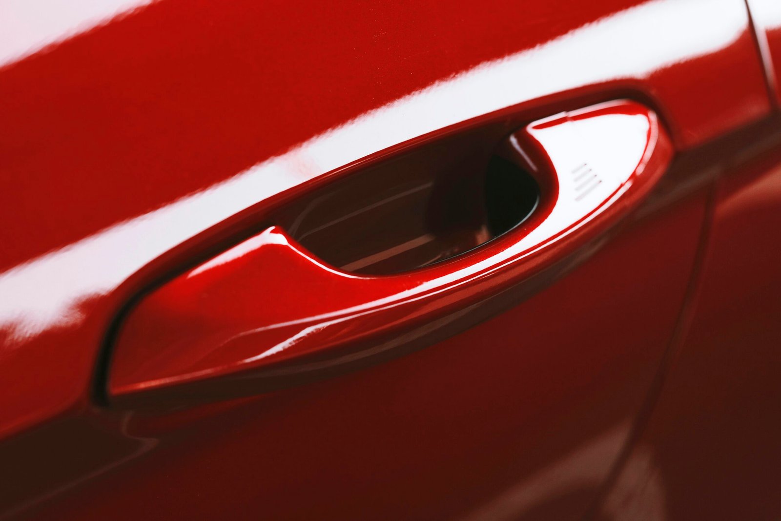 a close up of a red car door handle