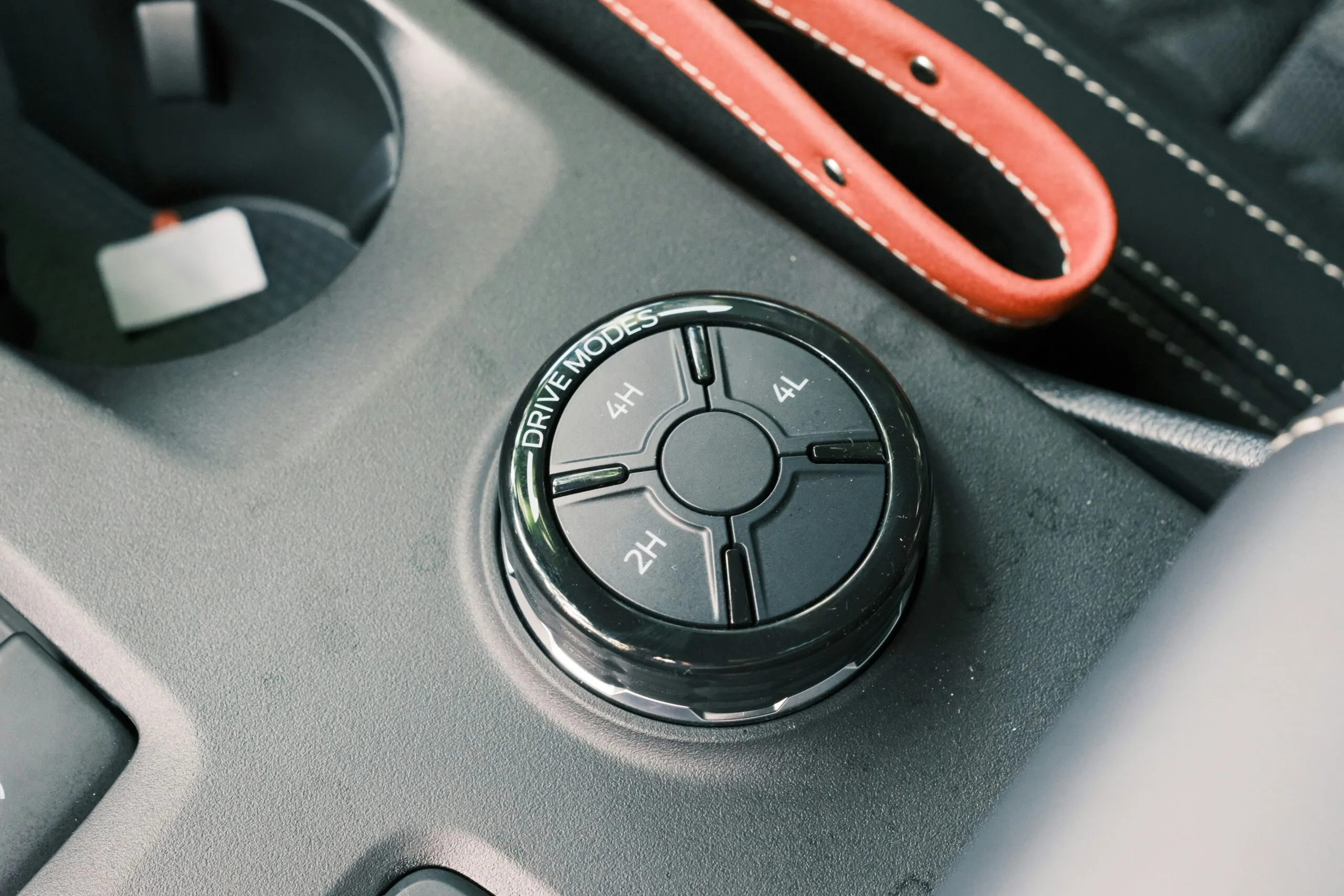 Car's drive mode selector and accessories are shown.