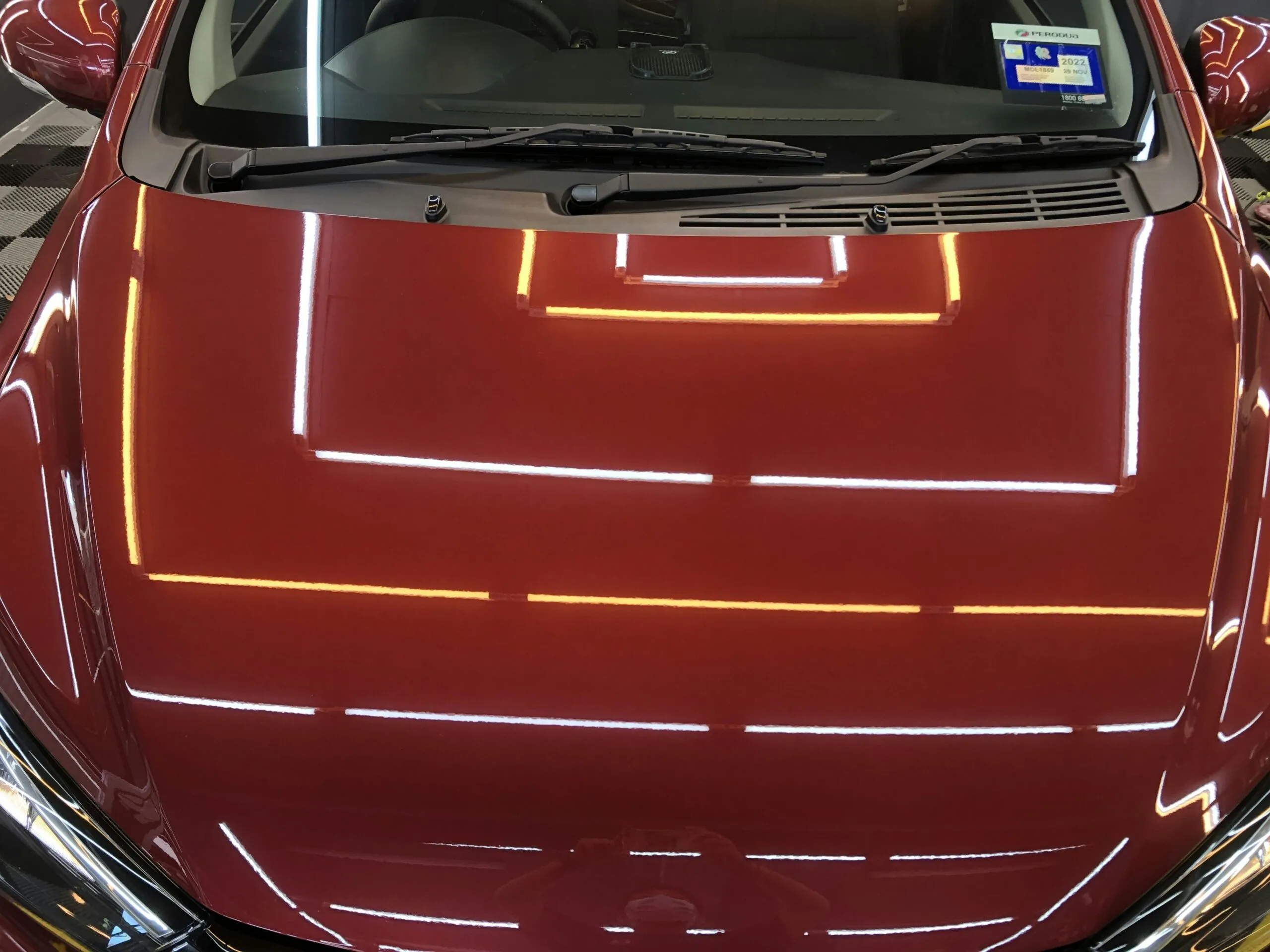 the hood of a red car with yellow lines on it