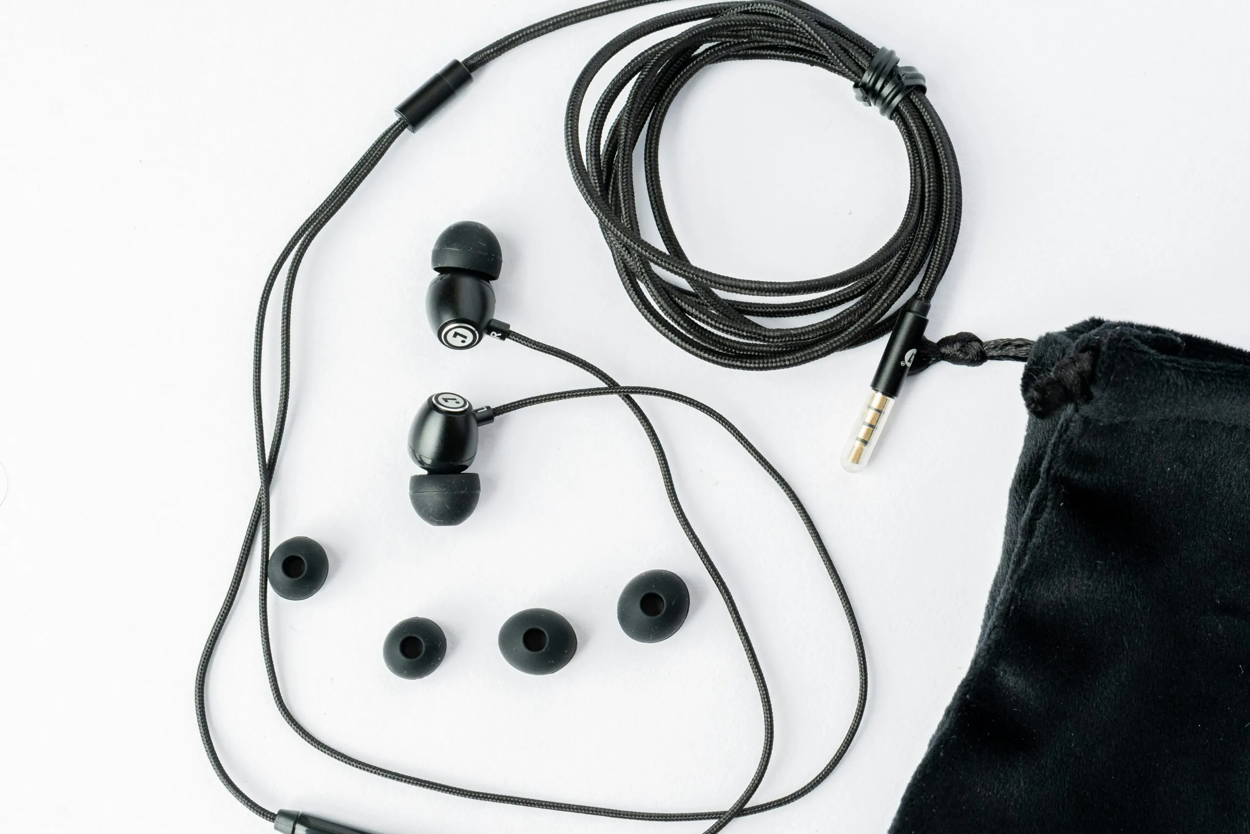 A pair of headphones and a bag on a white surface