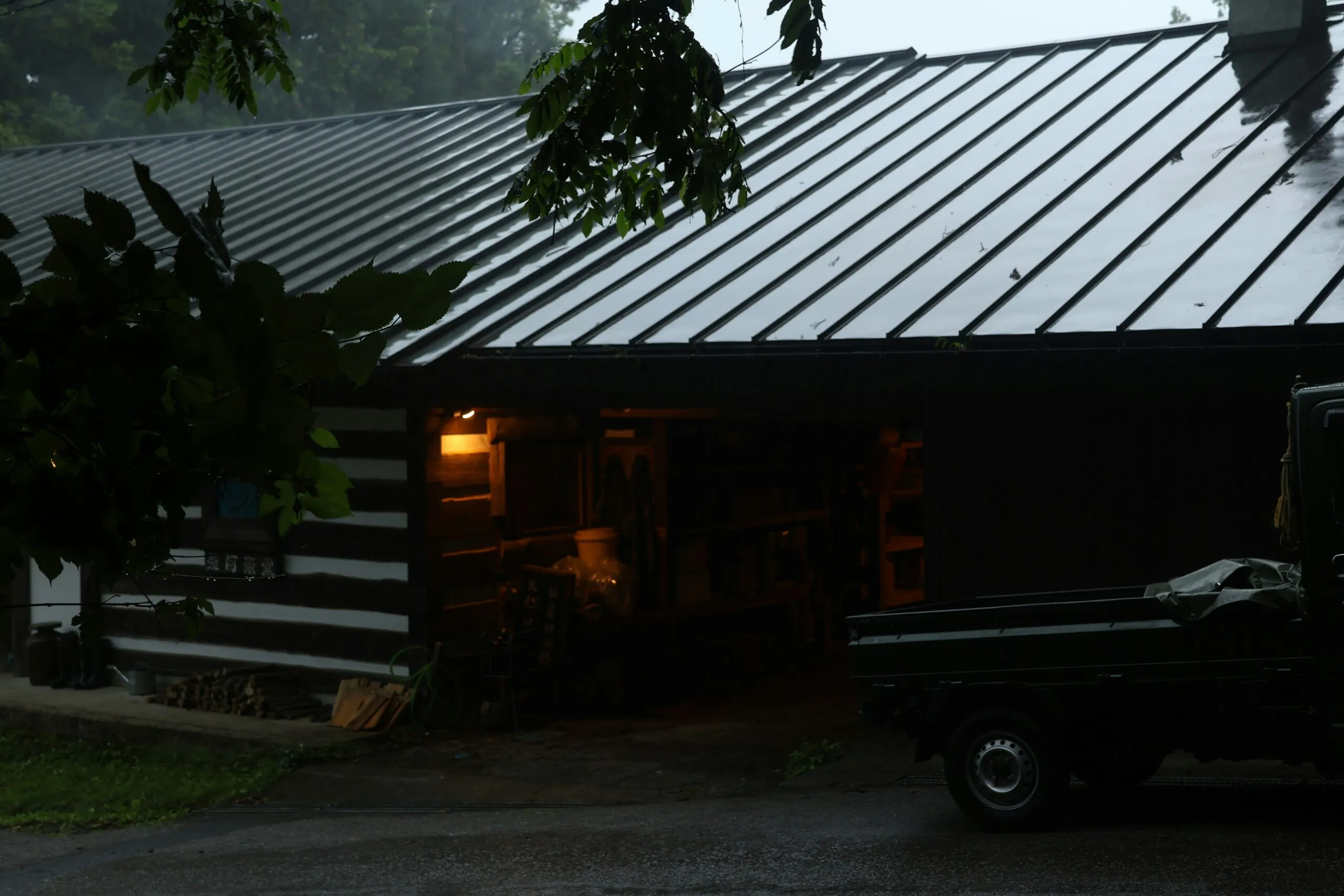 A rustic cabin is seen in the rain.