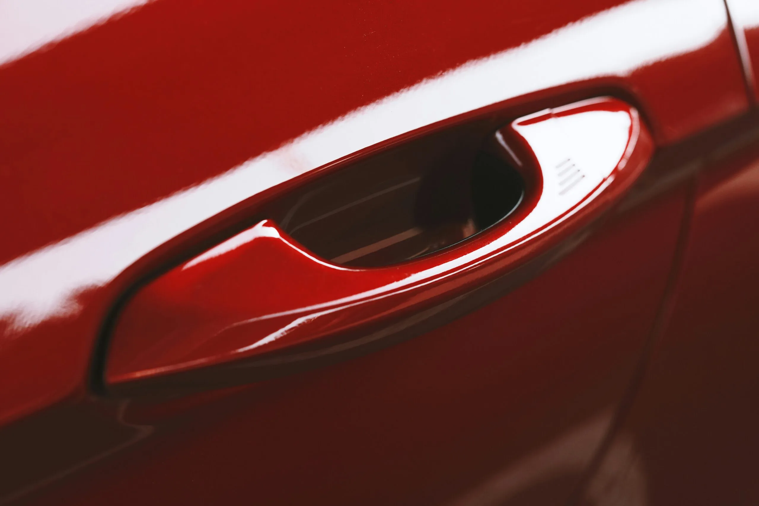 a close up of a red car door handle