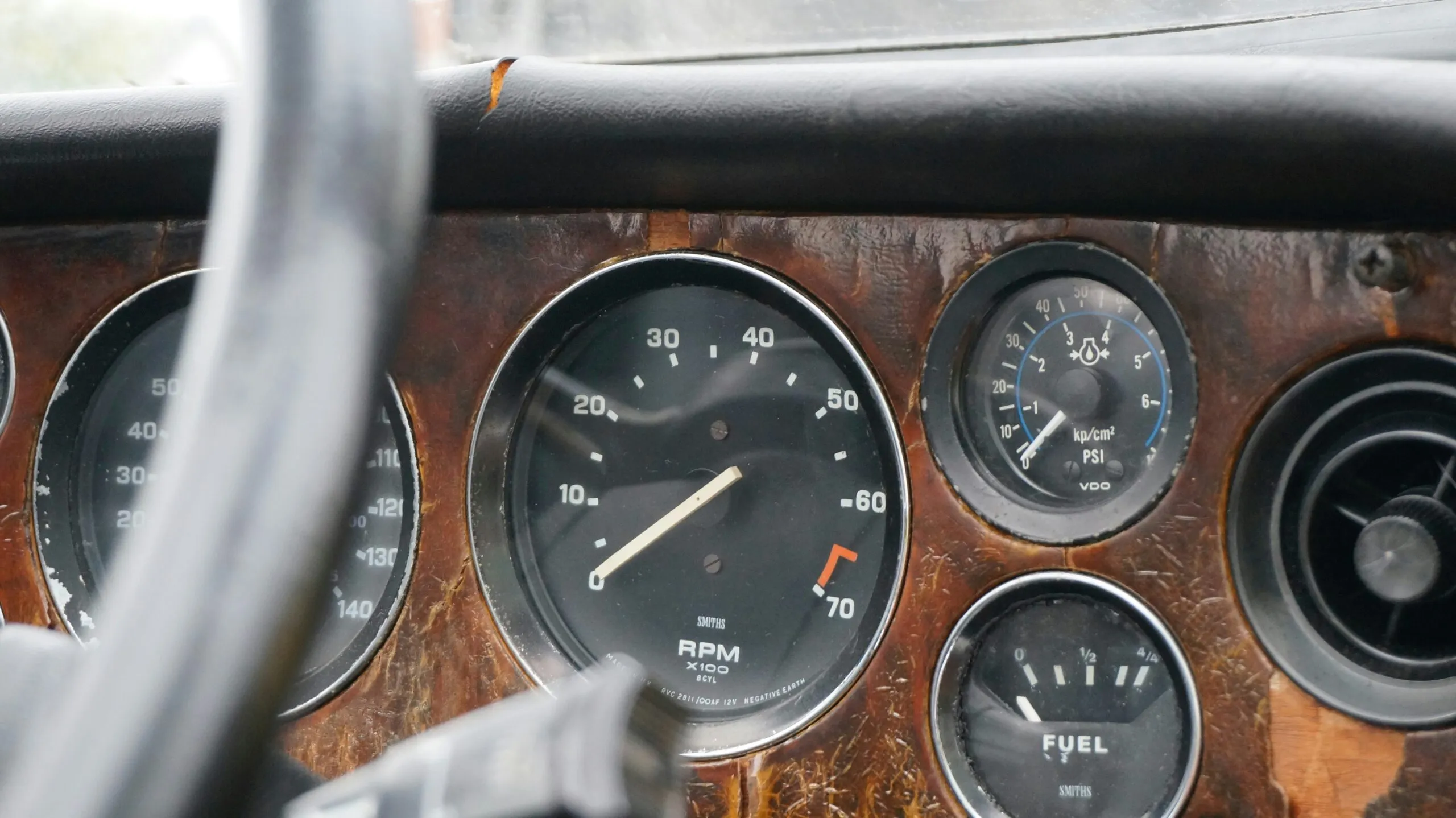 Close-up of a vintage car dashboard with gauges.