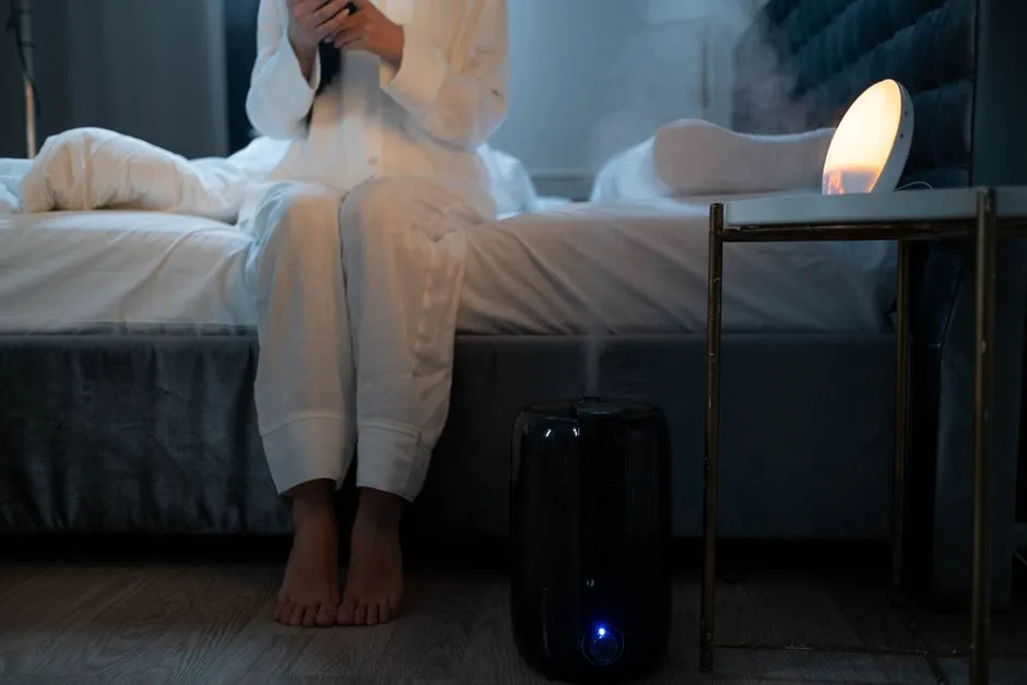 A serene bedroom scene with humidifier mist illuminating soft lighting, creating a calm atmosphere.