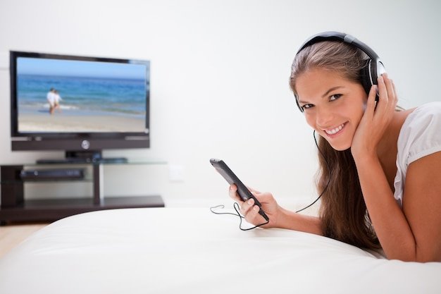 Smiling woman listening to music in the living room
