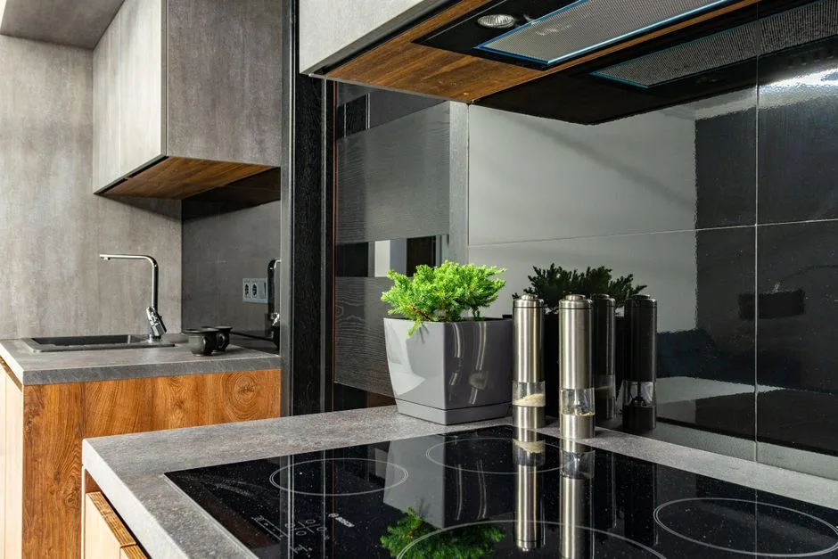Contemporary kitchen interior featuring a stylish induction cooktop, stainless steel fixtures, and minimalist design.