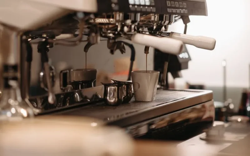 Espresso machine brewing fresh coffee in a cafe, focusing on drip into cup.