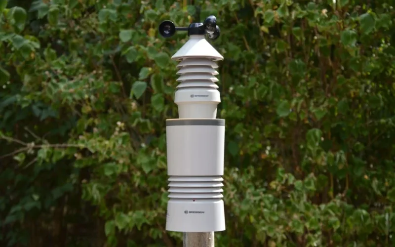 Close-up of a wireless weather station amidst green foliage, perfect for modern research and technology use.