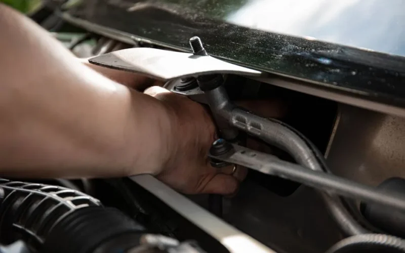 Close-up of a mechanic's hands working on car engine maintenance.