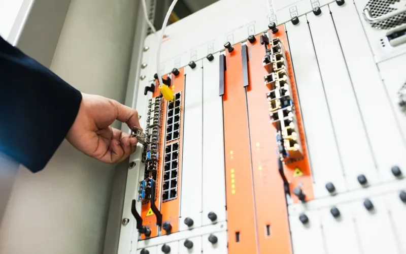 Close-up of a hand adjusting network equipment in a data center.