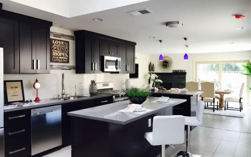 Sleek open-plan kitchen with modern decor, featuring stainless appliances and bar seating.