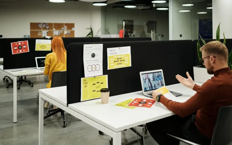 Colleagues working and collaborating virtually at a stylish modern office workspace.