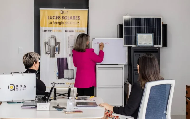 A team engaged in brainstorming solar energy solutions with panels and a whiteboard in an office.