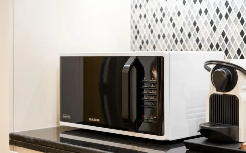 Stylish kitchen setup featuring a black microwave and coffee maker on a counter.