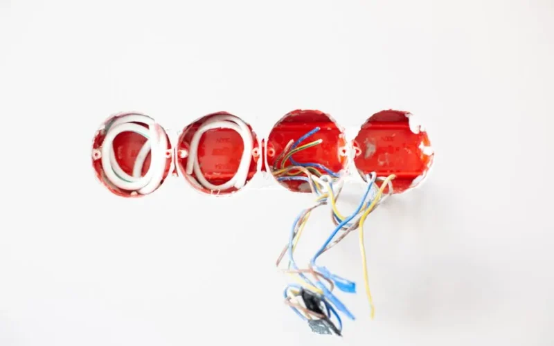 Close-up of exposed electrical wiring in wall sockets ready for installation. Ideal for home improvement contexts.