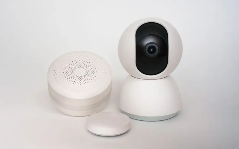 Modern minimalist smart home devices including security camera and sensors in white.