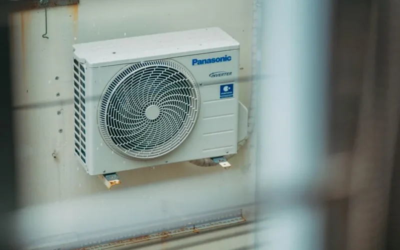 Air conditioner unit mounted outdoors on a building wall, showcasing modern HVAC technology.