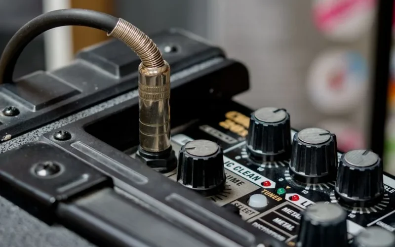 Detailed view of audio equipment featuring cable connection and control knobs.