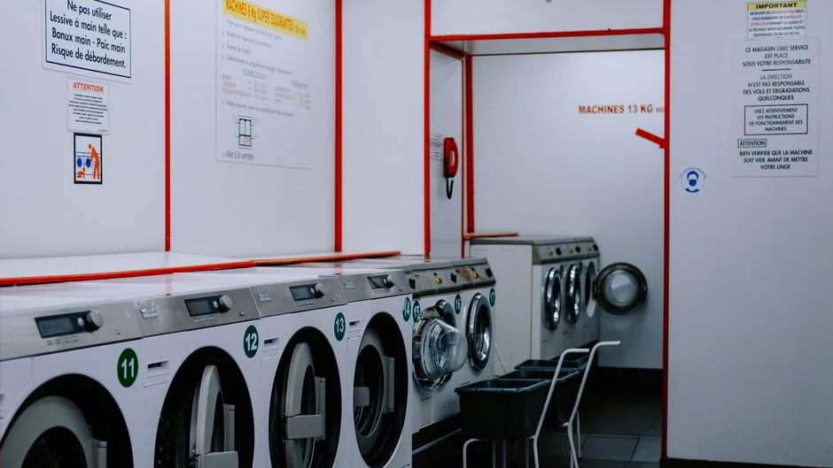 Inside a laundromat with washing machines lined up against the wall.